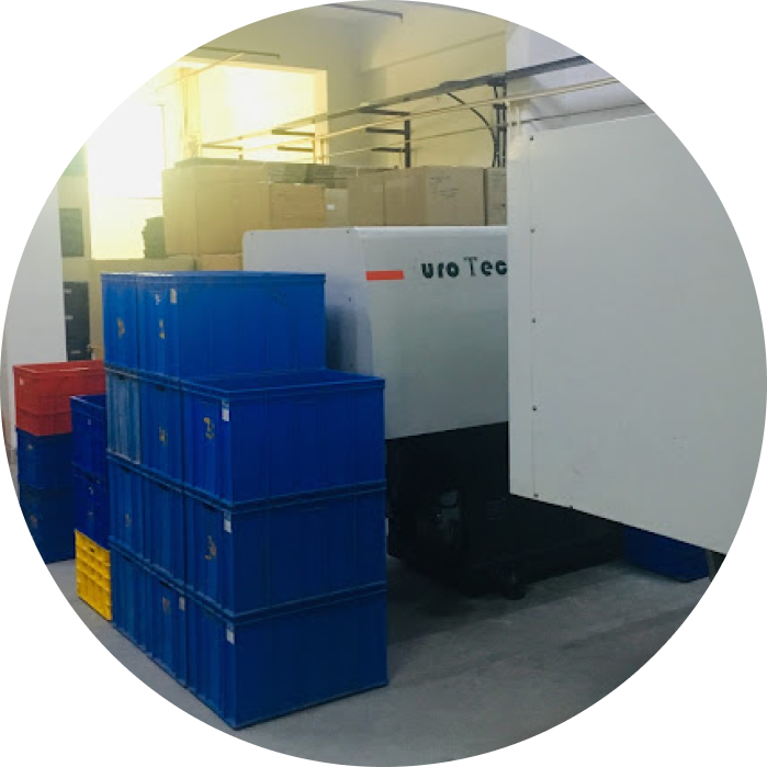 An Injection Moulding machine is near the plastic tray boxes and cartoons.